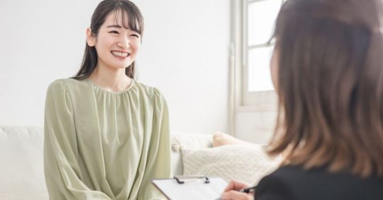 笑顔でカウンセリングを受けている若い女性
